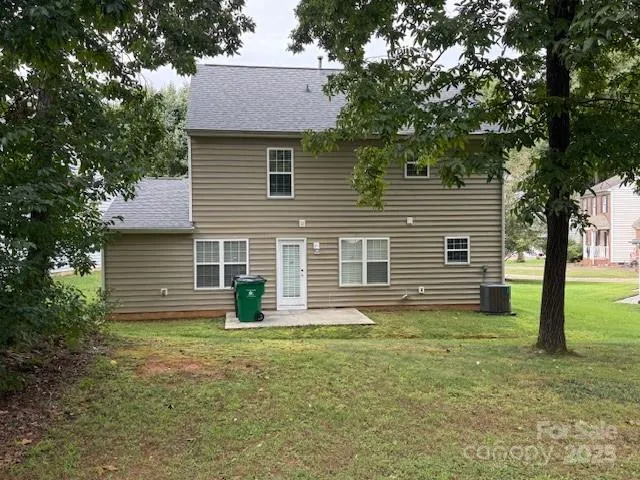 a view of a house with backyard and a tree