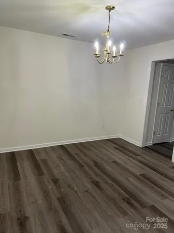 a view of wooden floor and chandelier in room