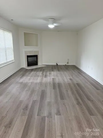 a view of empty room with wooden floor and fireplace