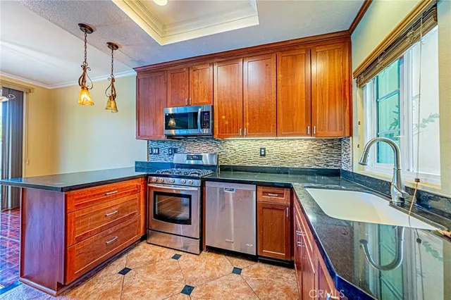 a kitchen with stainless steel appliances granite countertop wooden cabinets a sink and a stove