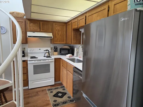 a kitchen with a refrigerator a stove a sink and cabinets
