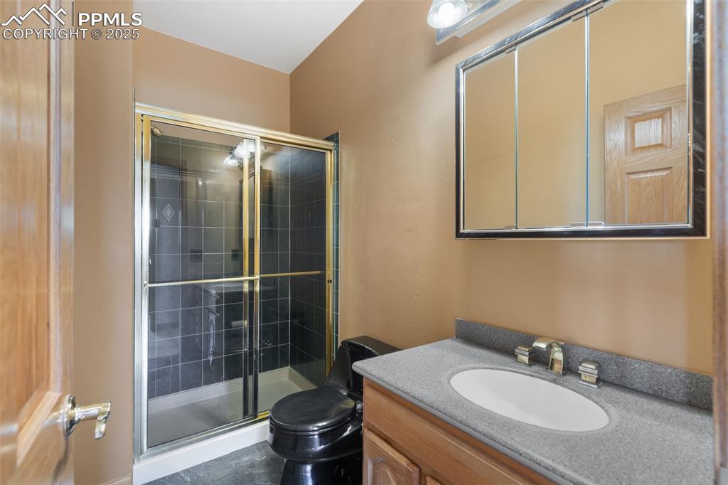 1680 Elk View Road Larkspur, CO 80118 - Photo 20 of 50 a bathroom with a sink toilet and shower