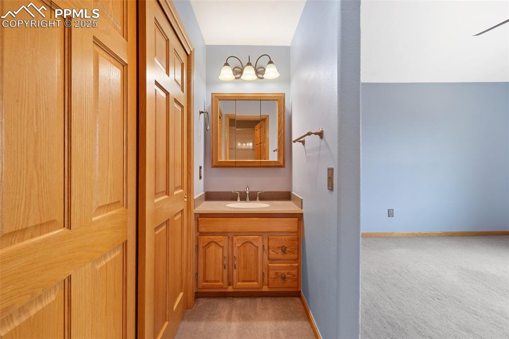 1680 Elk View Road Larkspur, CO 80118 - Photo 25 of 50 a bathroom with a granite countertop sink and a mirror