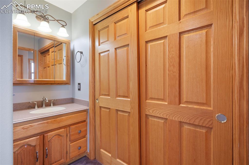 1680 Elk View Road Larkspur, CO 80118 - Photo 27 of 50 a bathroom with a sink a vanity and a mirror
