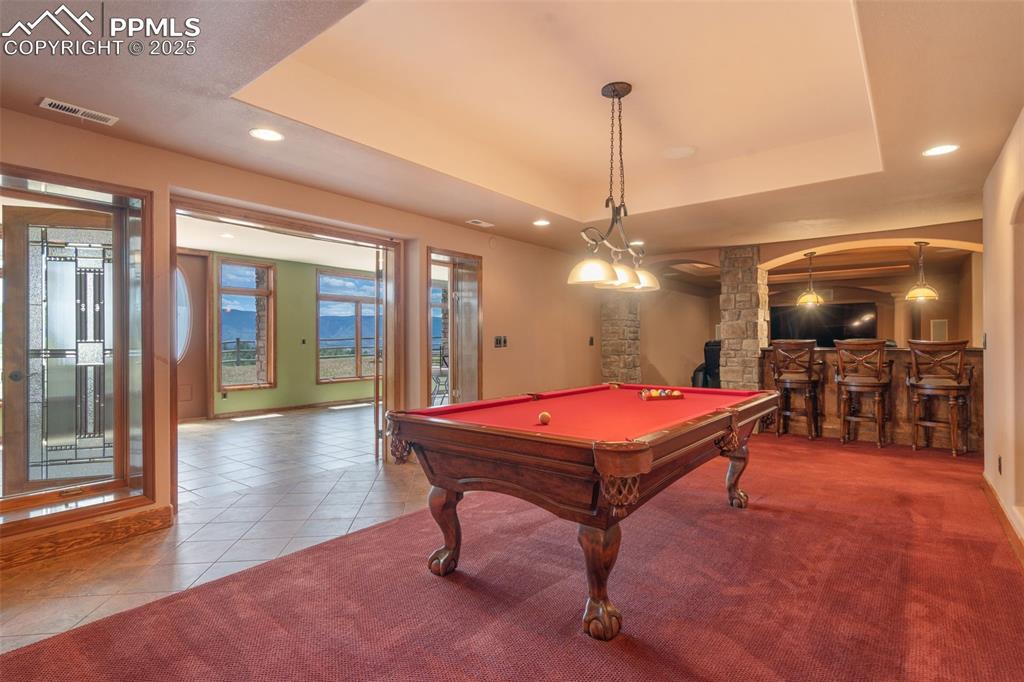 1680 Elk View Road Larkspur, CO 80118 - Photo 35 of 50 a room with pool table windows and a chandelier