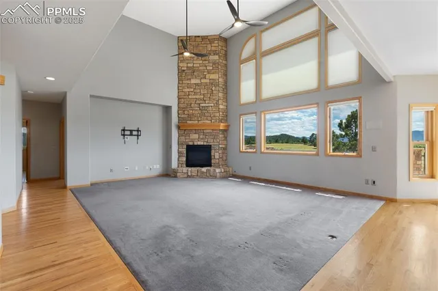 an empty room with windows and fireplace