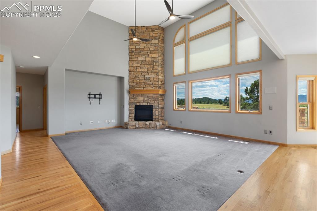 1680 Elk View Road Larkspur, CO 80118 - Photo 9 of 50 an empty room with windows and fireplace