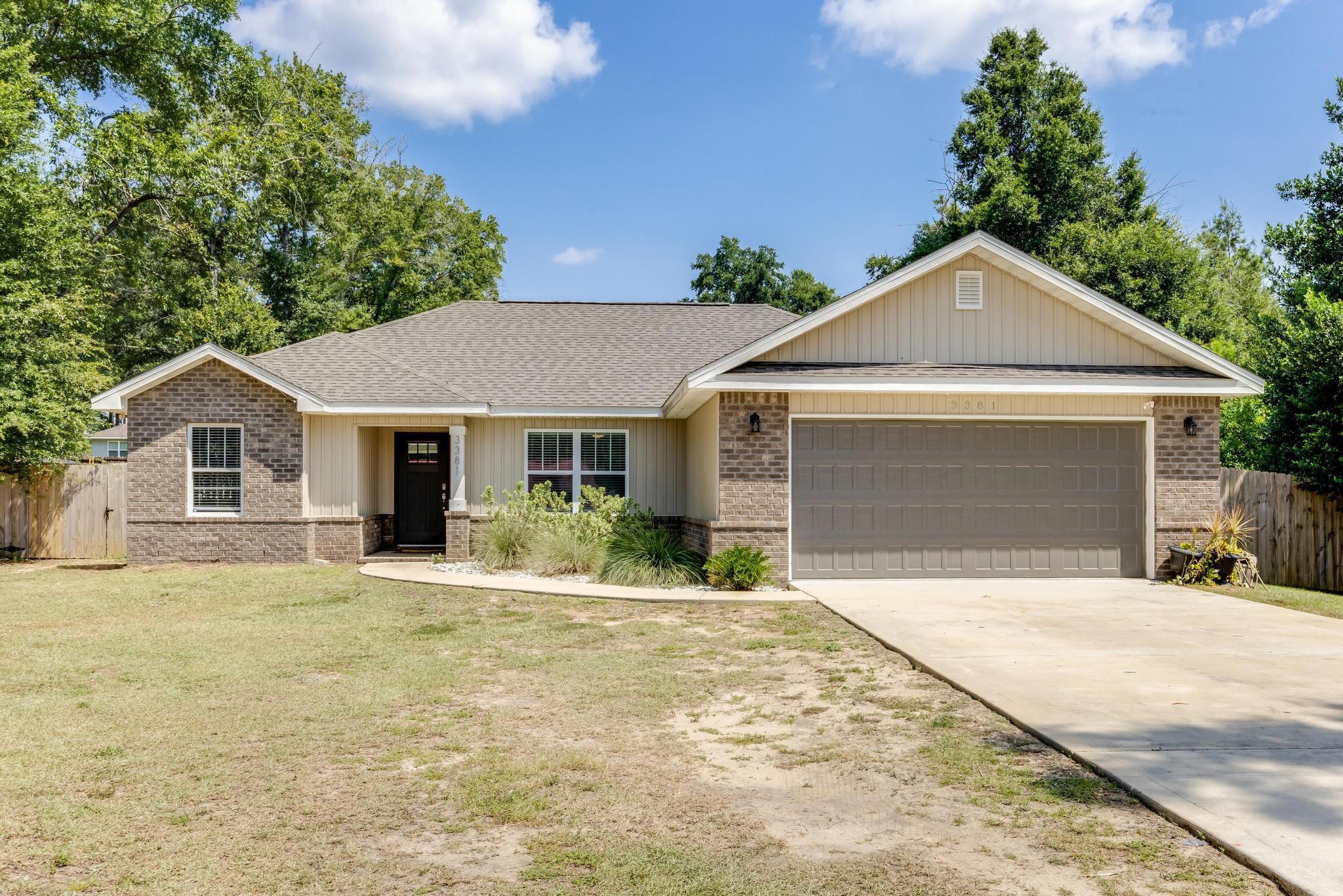 3381 Auburn Road Crestview, FL 32539 - Photo 1 of 46 a front view of a house with yard and trees in the background