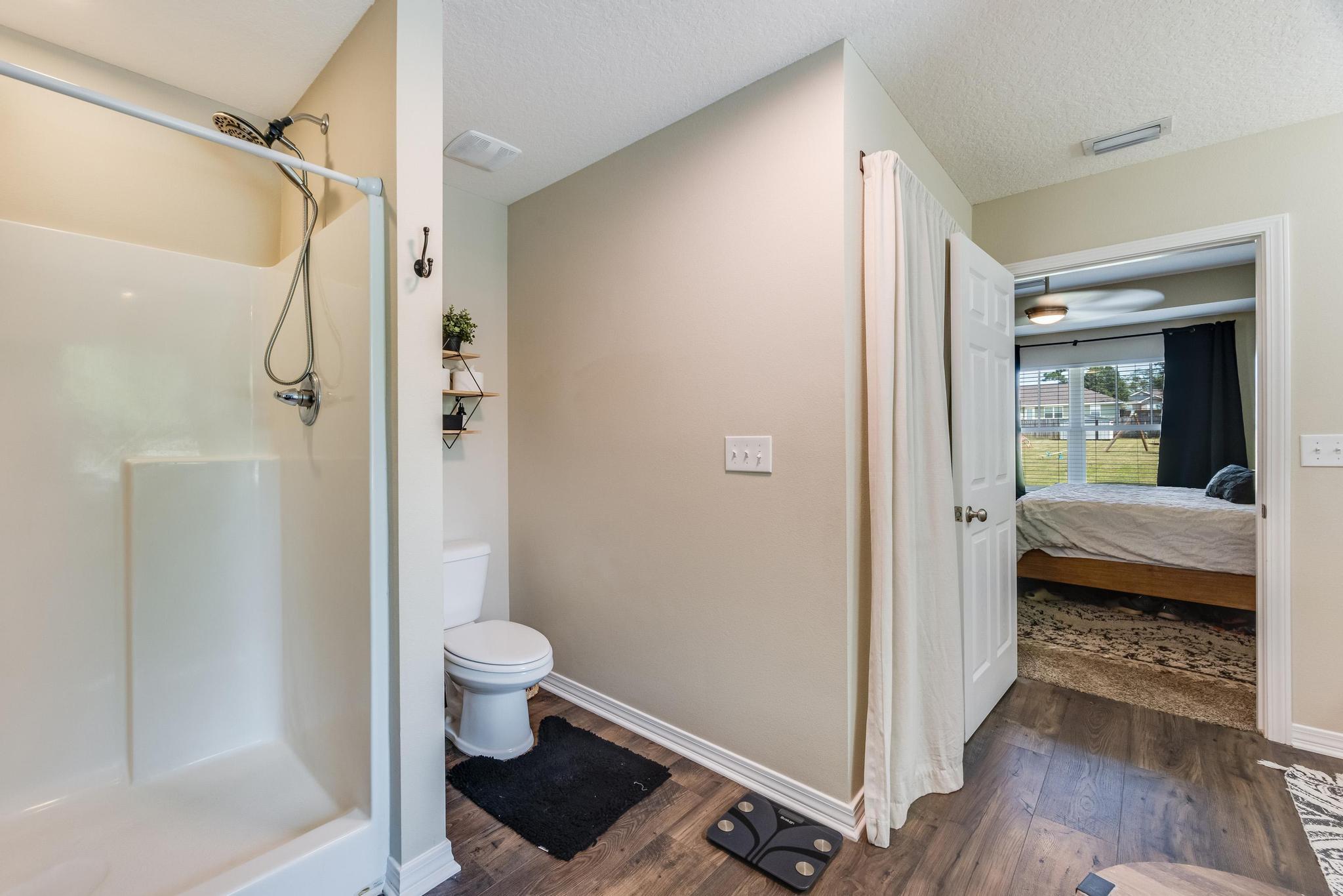 3381 Auburn Road Crestview, FL 32539 - Photo 24 of 46 a bathroom with a glass door shower and a toilet