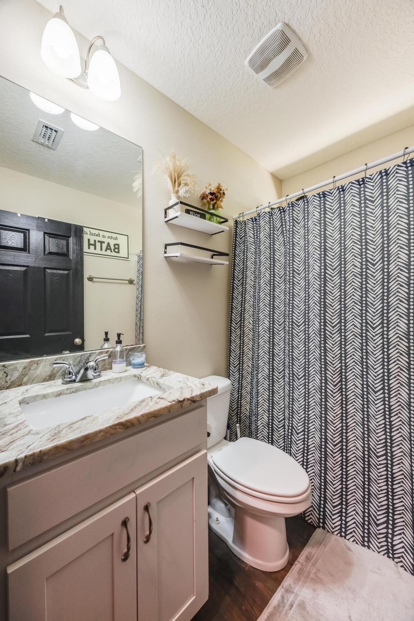 3381 Auburn Road Crestview, FL 32539 - Photo 32 of 46 a bathroom with a granite countertop toilet sink and mirror