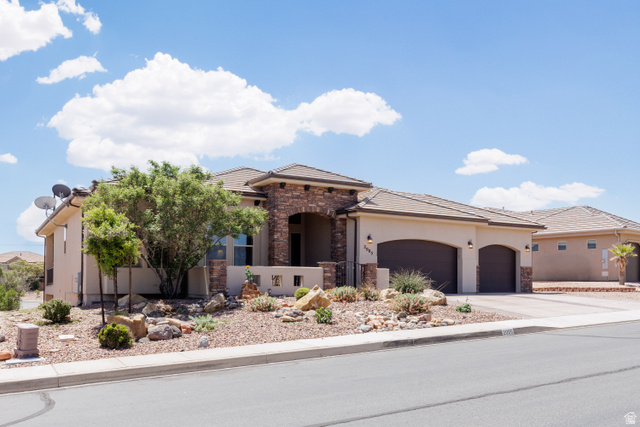 2005 West 450 S Circle St. George, UT 84770 - Photo 2 of 57 Exterior featuring stucco siding with stone accents, a tile roof, and desert landscaping