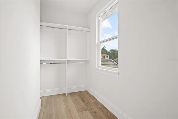 an empty room with wooden floor and ceiling fan