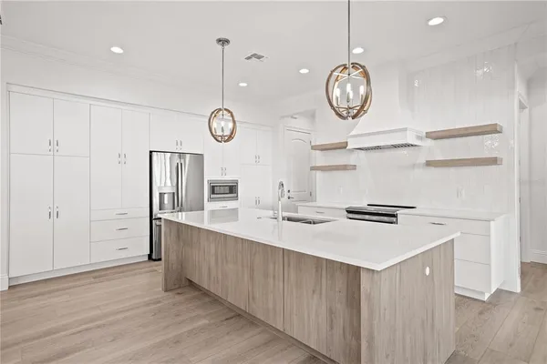 a large kitchen with a lot of counter space and wooden floor