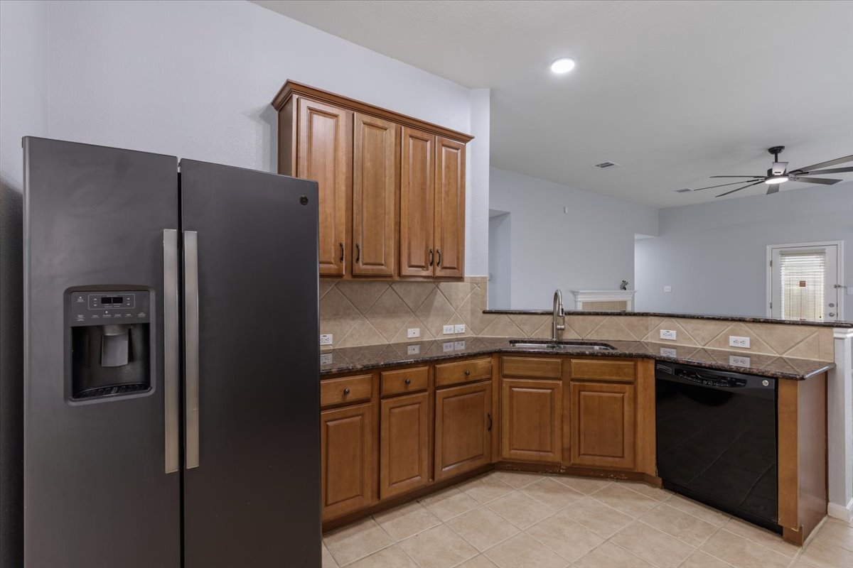 17812 Masi Loop Pflugerville, TX 78660 - Photo 12 of 38 Kitchen featuring a side-by-side refrigerator, wood cabinetry, stone countertops, and tile flooring