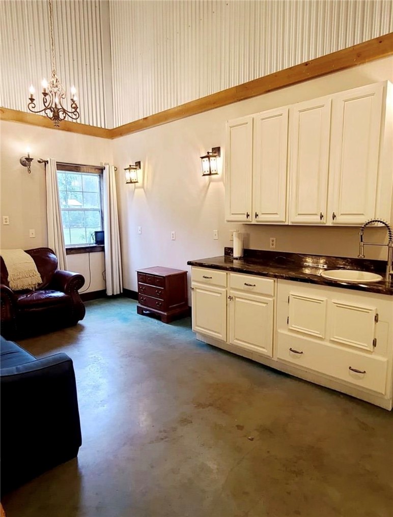 5325 County Road 2291 Centerville, TX 75833 - Photo 30 of 31 Kitchen featuring dark countertops, concrete floors, white cabinets, and a chandelier