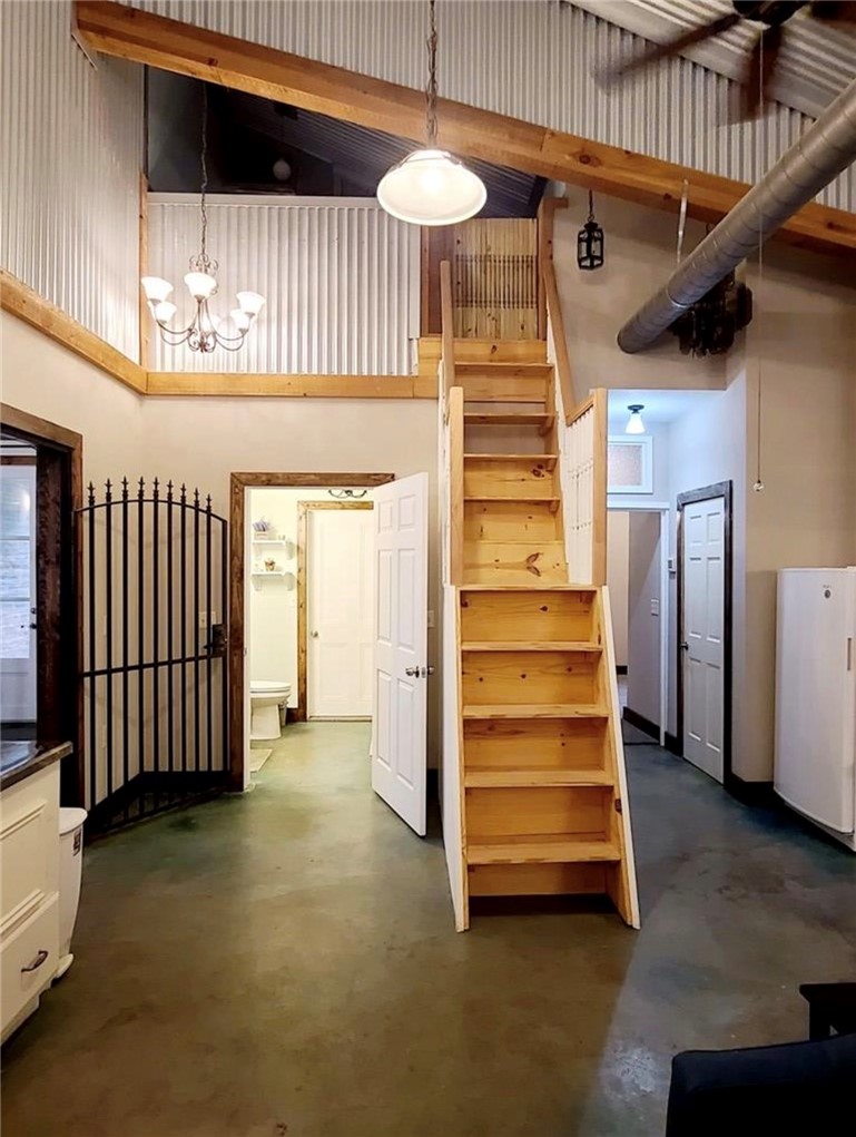 5325 County Road 2291 Centerville, TX 75833 - Photo 7 of 31 Stairway with a high ceiling, concrete floors, and suspended lighting