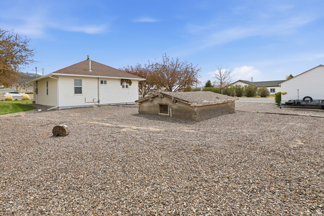82 South 100 West Lyman, UT 84749 - Photo 7 of 27 Rear view of house with a shingled roof