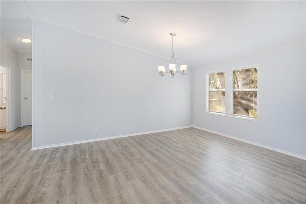 4775 Highway 91 Denison, TX 75020 - Photo 14 of 19 an empty room with wooden floor chandelier and windows