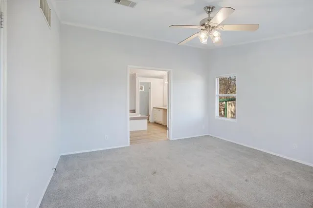 an empty room with a fan and a window
