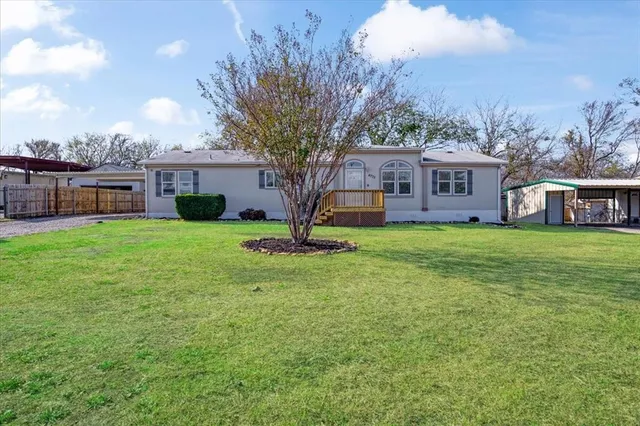a view of a house with a yard and trees