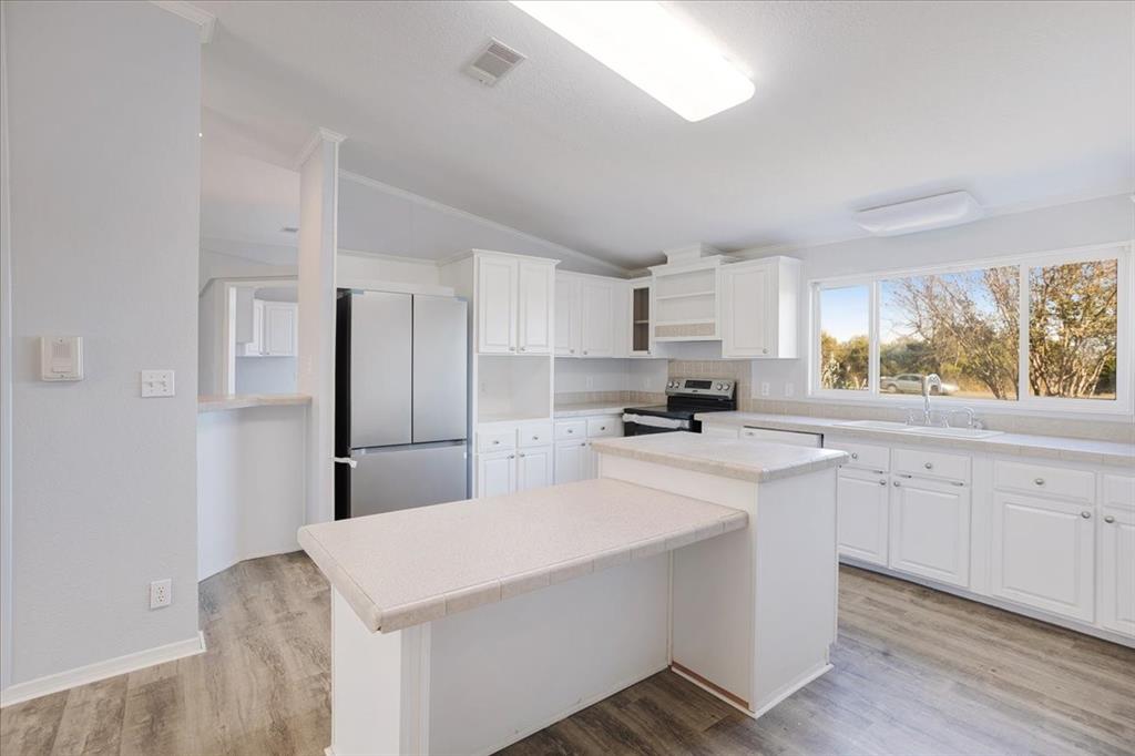 4775 Highway 91 Denison, TX 75020 - Photo 4 of 19 a kitchen with stainless steel appliances a sink a stove a refrigerator cabinets and a window