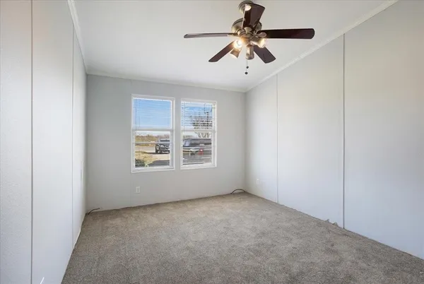 en empty room with windows and ceiling fan