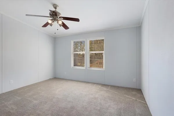 an empty room with a window and a ceiling fan