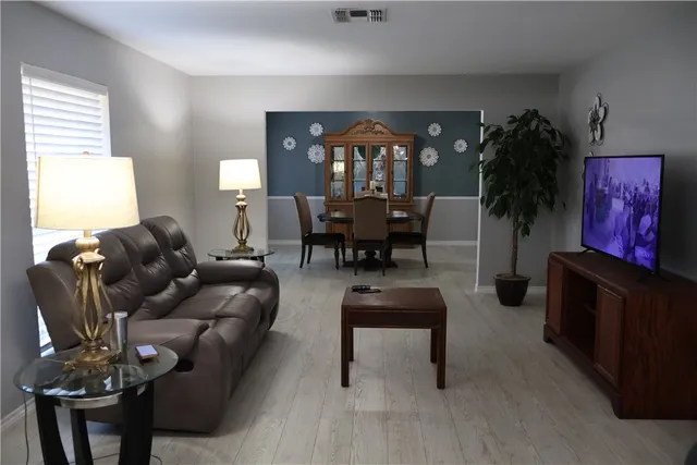 a living room with furniture and wooden floor