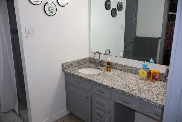 a bathroom with a granite countertop sink and a mirror