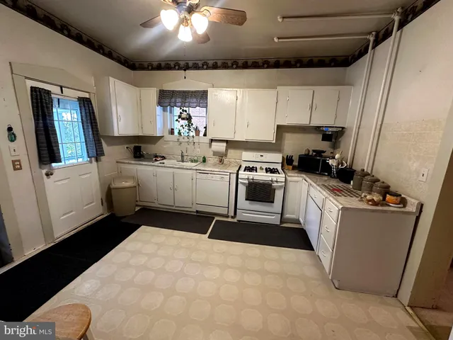 a kitchen with stainless steel appliances kitchen island granite countertop a stove sink and cabinets