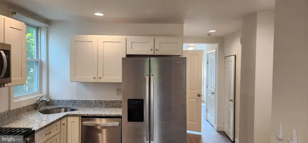 a kitchen with stainless steel appliances granite countertop a refrigerator and a sink