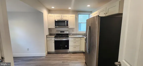 a kitchen with stainless steel appliances a refrigerator stove and microwave