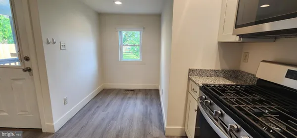 a kitchen with a wooden floor and a stove top oven