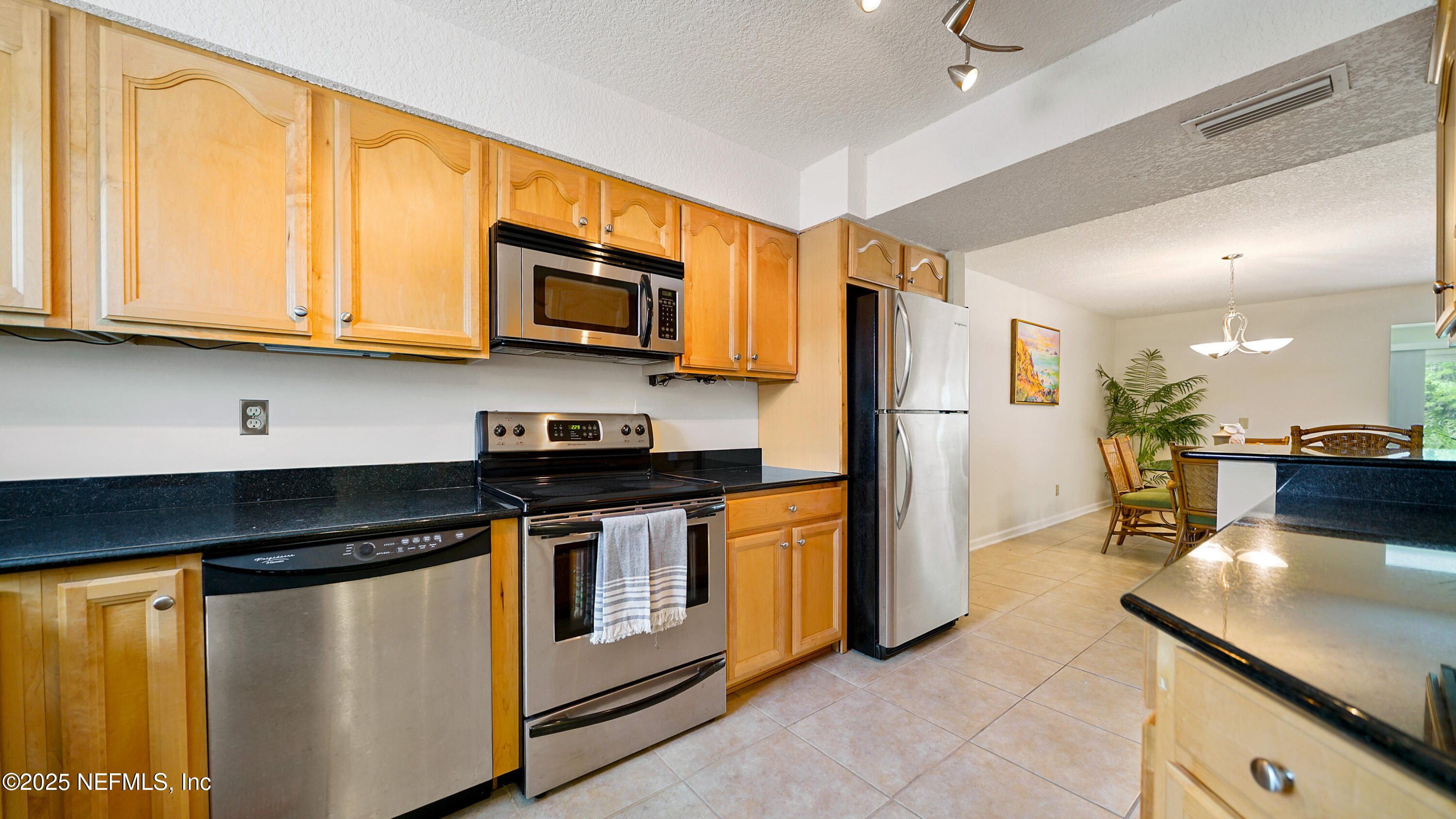 2233 Seminole Road, Unit 7 Atlantic Beach, FL 32233 - Photo 21 of 52 a kitchen with stainless steel appliances granite countertop a stove a sink and a microwave