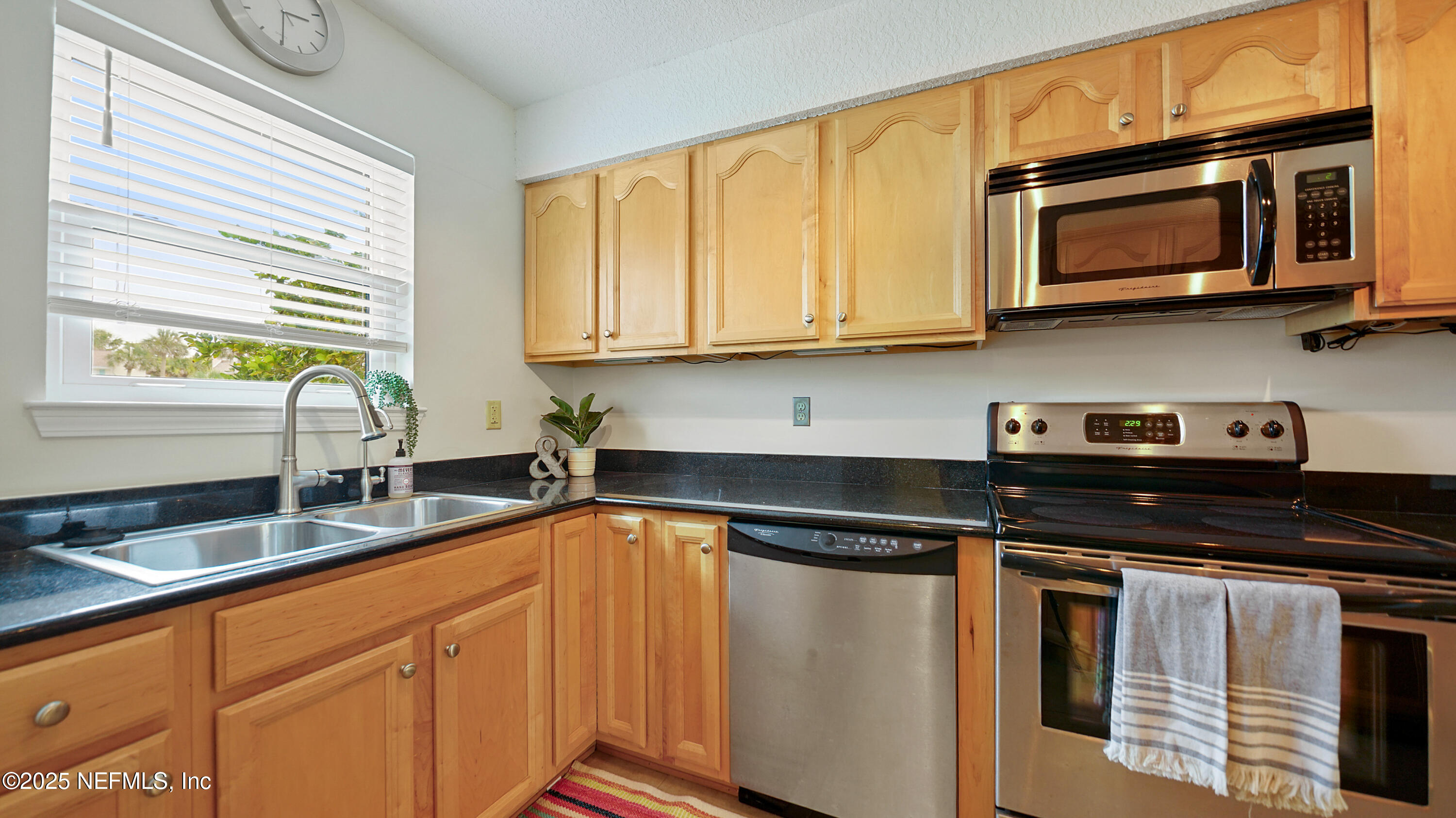 2233 Seminole Road, Unit 7 Atlantic Beach, FL 32233 - Photo 22 of 52 a kitchen with granite countertop cabinets stainless steel appliances a sink and window