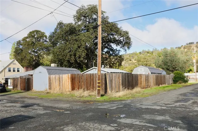 a view of a house with a yard and wooden fence