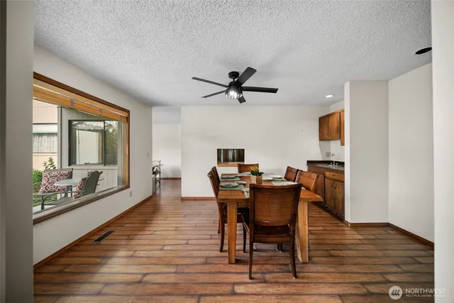 a view of a kitchen with a fridge and wooden floor