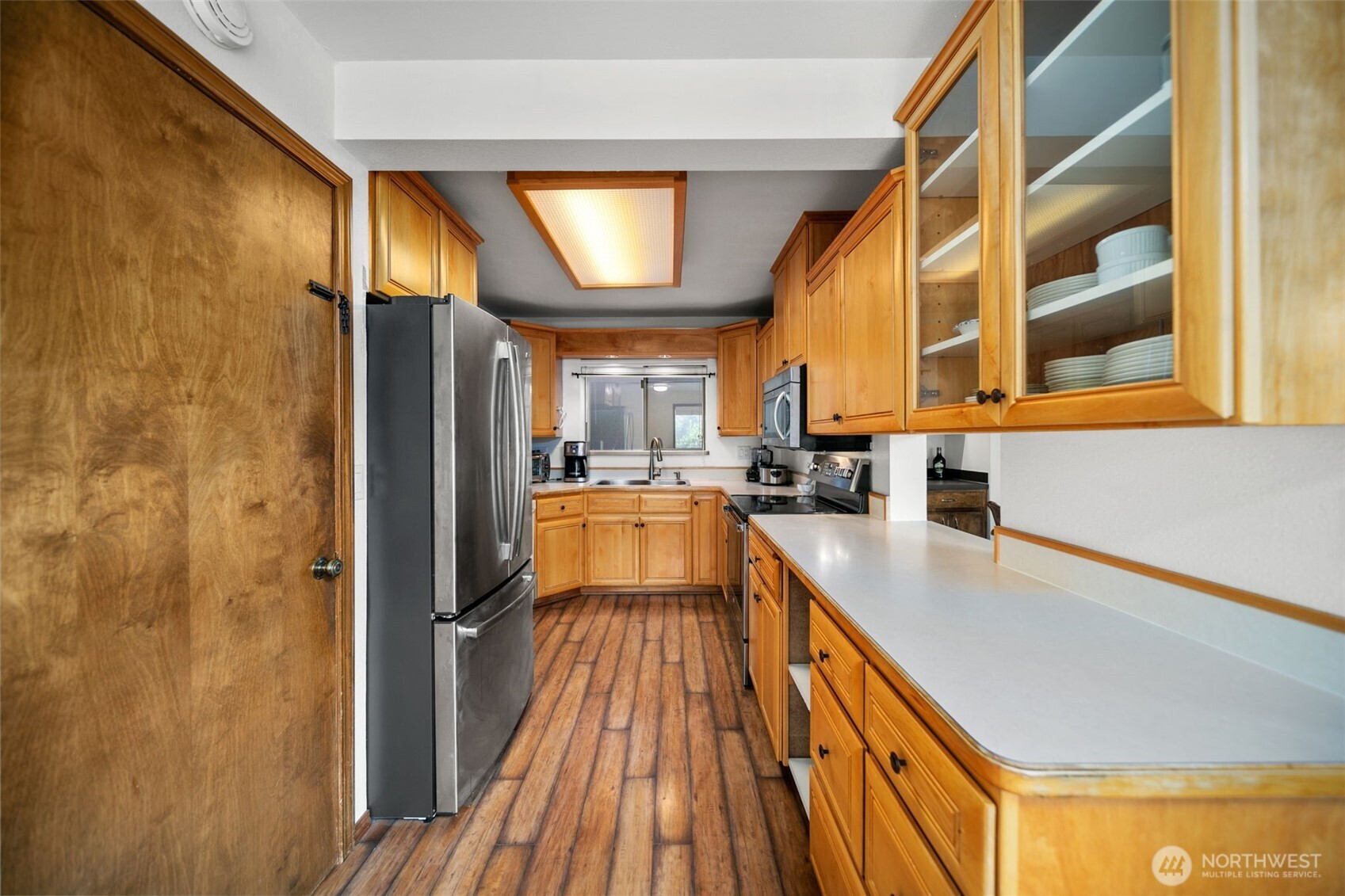 225 19th Street Northeast, Unit 23 East Wenatchee, WA 98802 - Photo 14 of 40 a view of a kitchen with a fridge and wooden floor