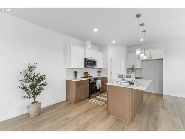 a kitchen with kitchen island granite countertop a sink a counter top space appliances and cabinets