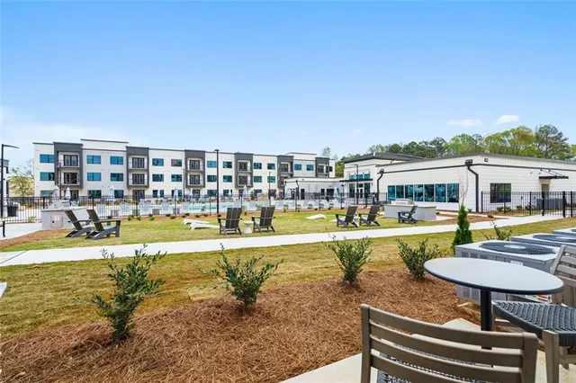 a view of swimming pool with lawn chairs and large trees
