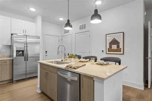 a kitchen with stainless steel appliances granite countertop a sink and refrigerator