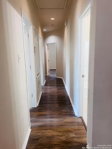 a view of a hallway with wooden floor