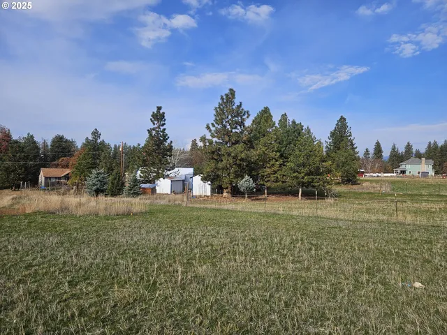 a backyard of a house with lots of green space and outdoor seating