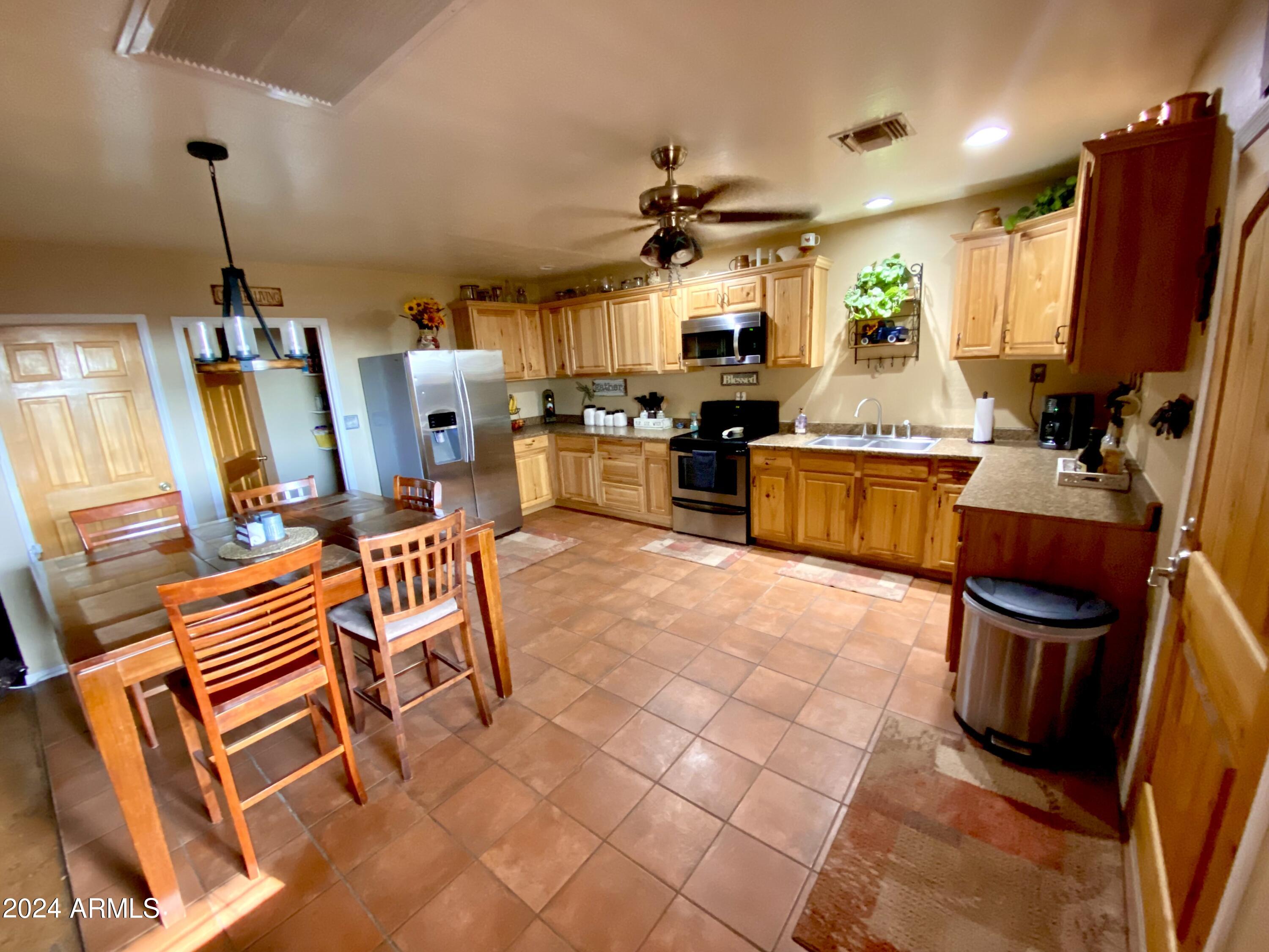 642 East Cornman Road Coolidge, AZ 85128 - Photo 15 of 64 a kitchen view with a table chairs and flat screen tv