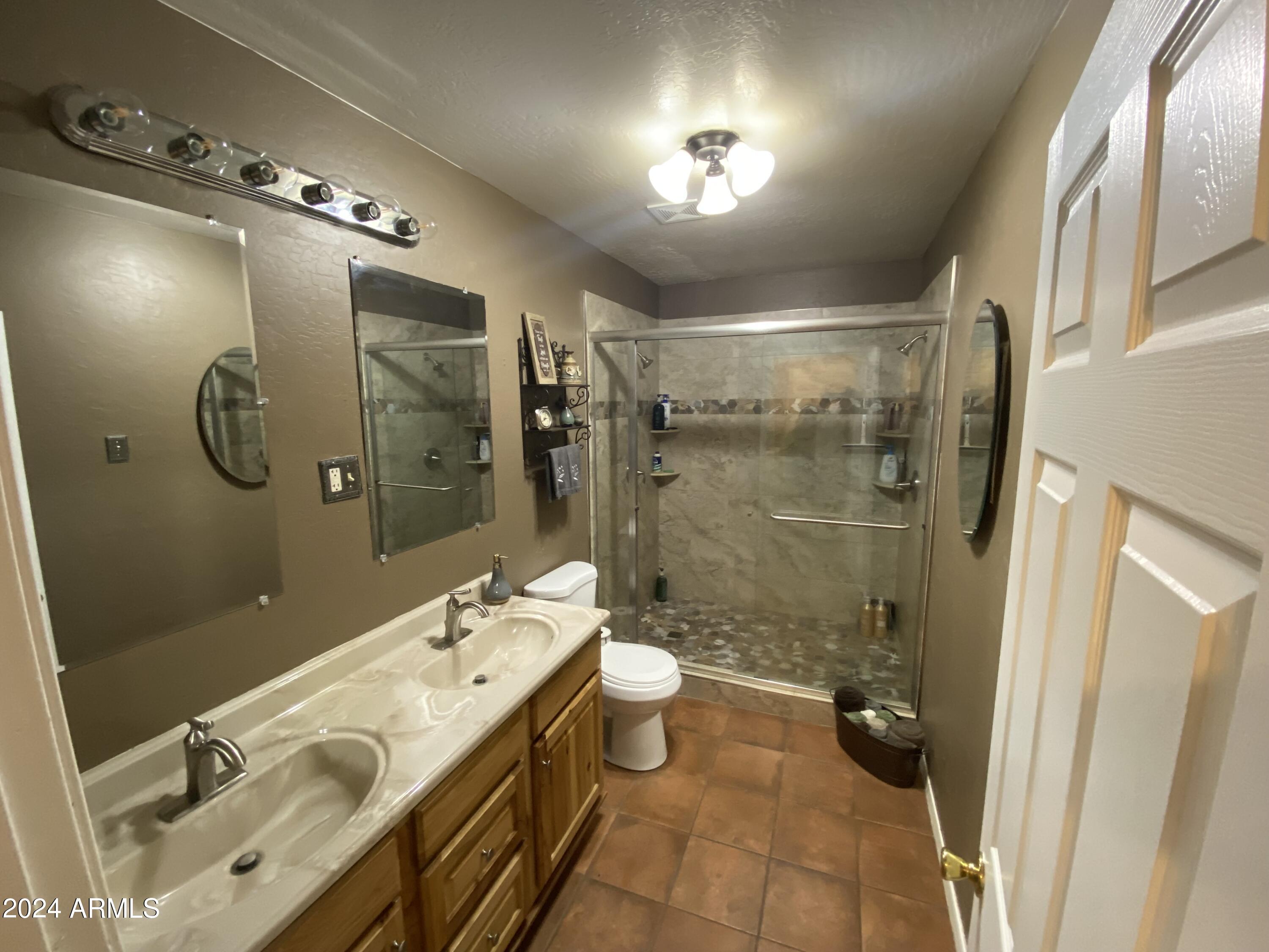 642 East Cornman Road Coolidge, AZ 85128 - Photo 19 of 64 a spacious bathroom with a double vanity sink toilet mirror and shower
