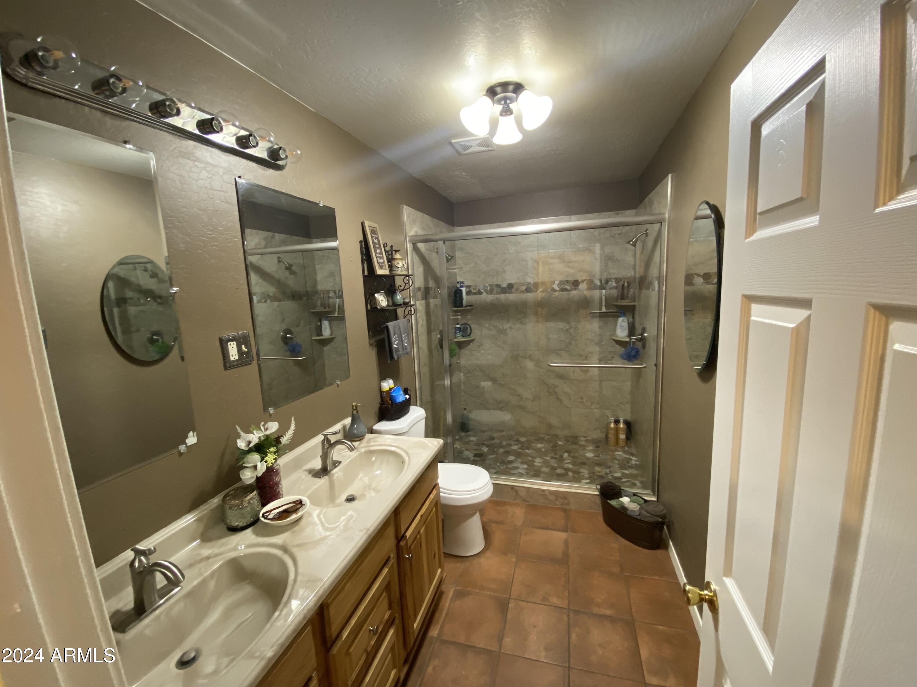642 East Cornman Road Coolidge, AZ 85128 - Photo 24 of 64 a bathroom with a double vanity sink toilet mirror and shower
