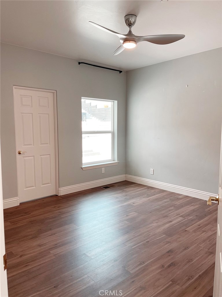 8560 Corriente Road Atascadero, CA 93422 - Photo 35 of 53 an empty room with wooden floor ceiling fan and windows