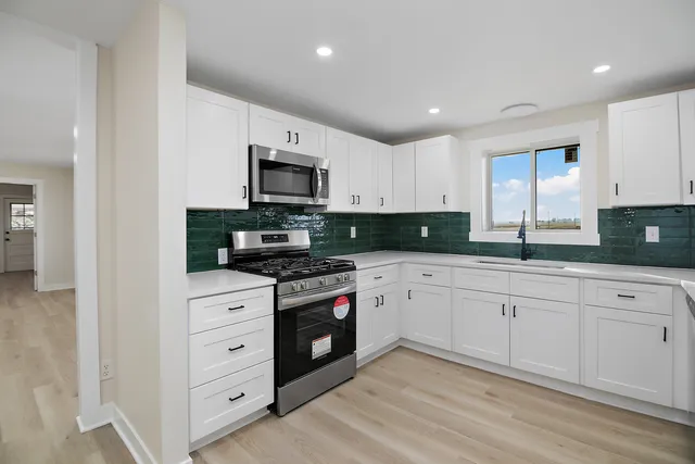a view of kitchen with sink and refrigerator