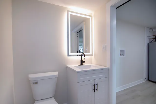 a bathroom with a sink a toilet and mirror