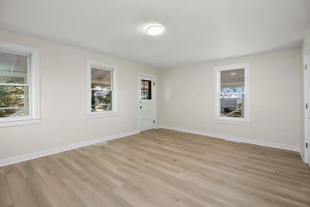 an empty room with windows and closet